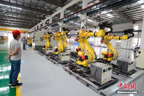 8月3日，长沙，众多机器人在厂房内集体跳舞。这些机器人由长泰机器人研制，兼具高速度与高精度双重优点及灵活的机械手腕，是一款低成本高性能的六轴轻型机器人，重复定位精度可达0.05毫米。记者 杨华峰 摄