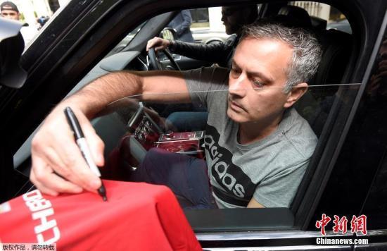 资料图：图为执教曼联期间，穆里尼奥在离开伦敦新家的途中，有曼联球迷递上球衣索要穆里尼奥的签名。
