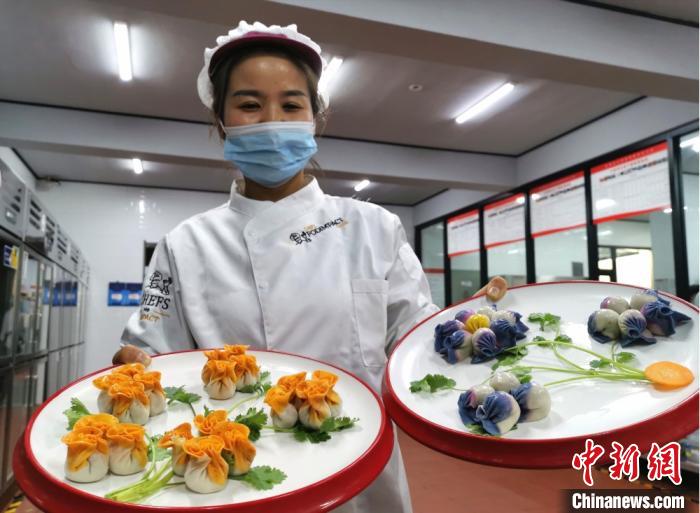 图为金昌市一宾馆的厨娘徐换弟介绍创意七彩饺子宴。　闫姣 摄