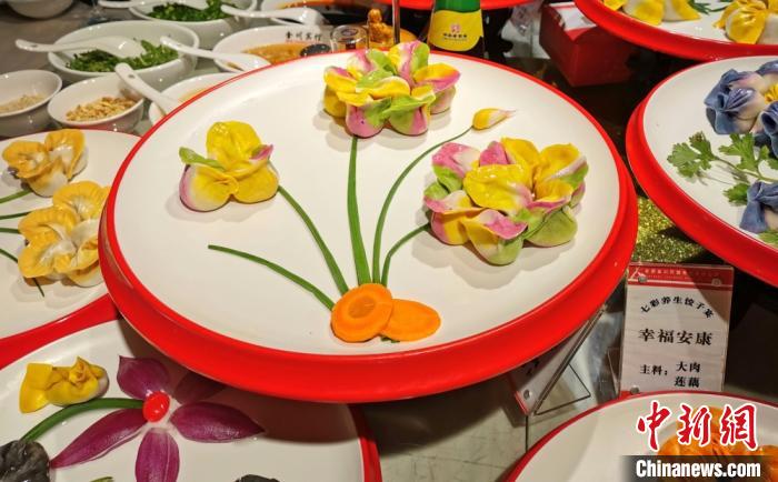 图为“七彩饺子”，配以胡萝卜和小葱等摆盘，形成花朵的样子。　闫姣 摄