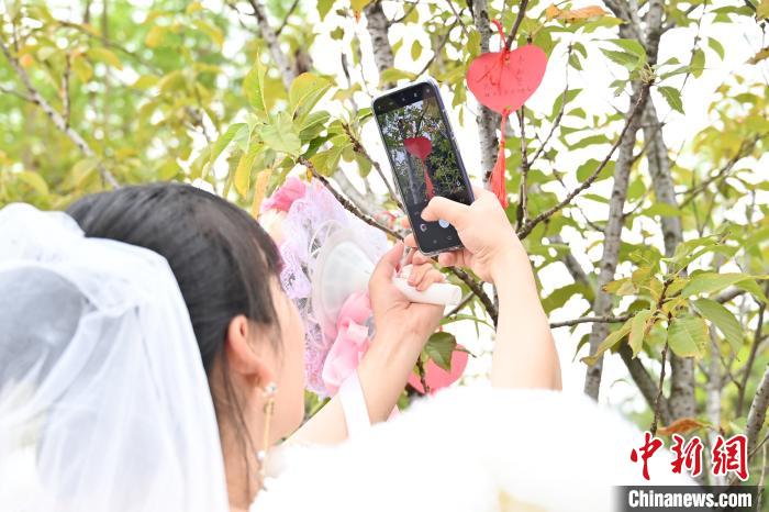 一位新娘拿手机拍下自己写下的心愿。　黄恋 摄